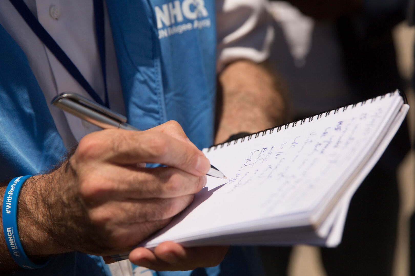UNHCR Mitarbeiter mit Notizheft in der Hand