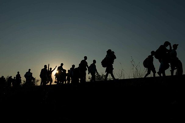 Gruppe von Flüchtlingen im Sonnenuntergang