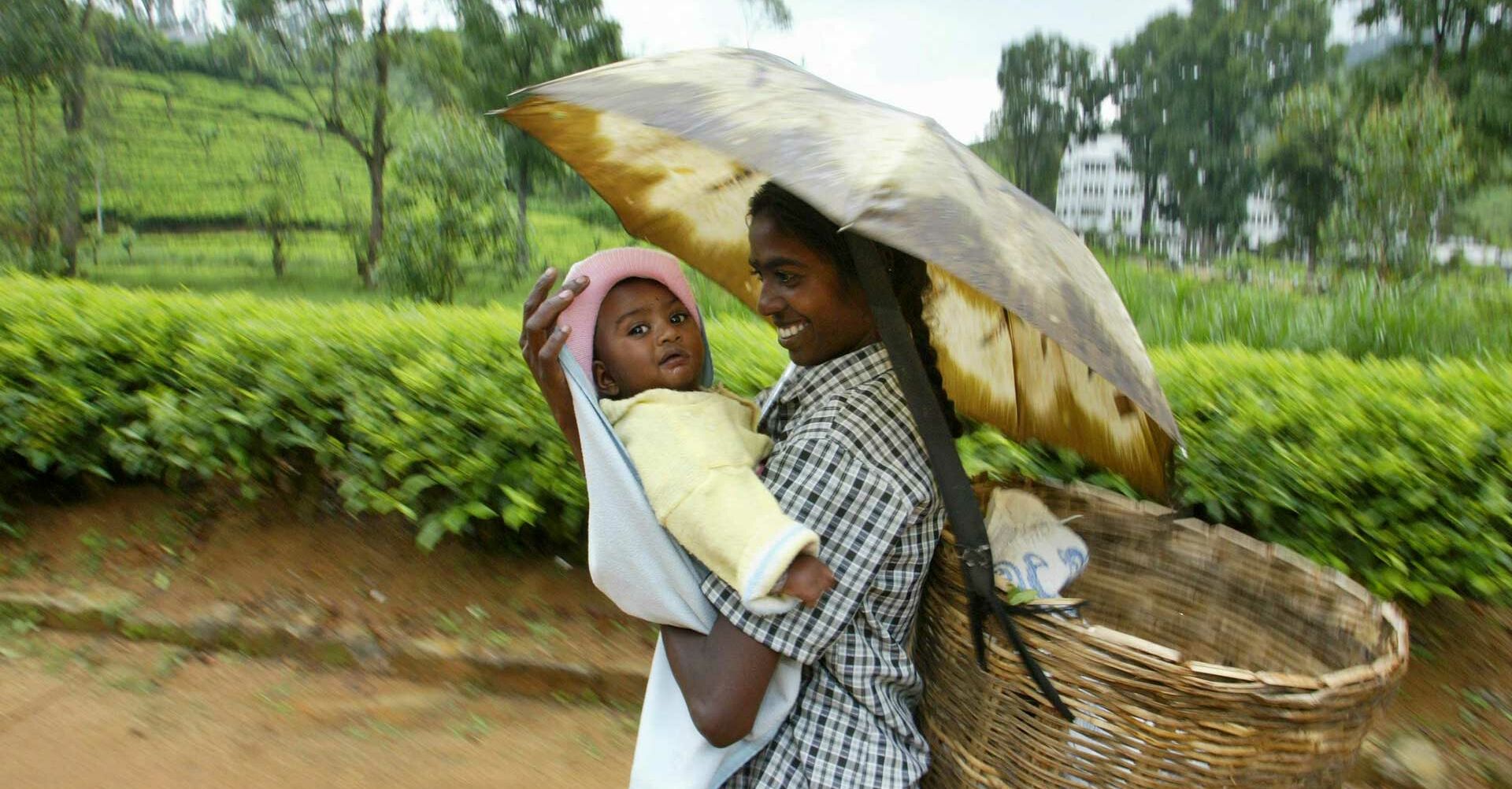 Mädchen mit kleinen Kind auf dem Arm unter Regenschirm, Staatenlose RF140040-1920x1080.jpg