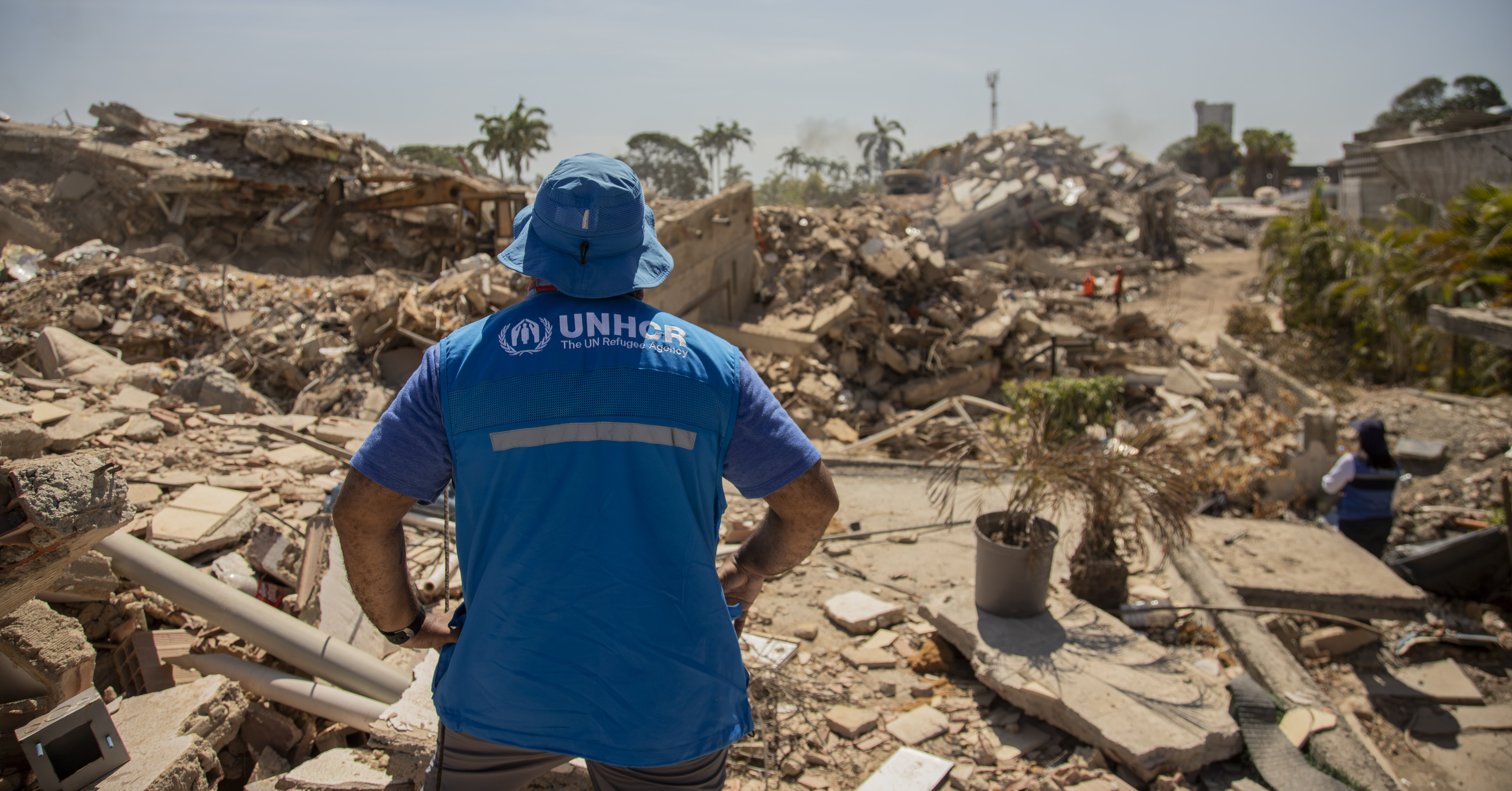 UNHCR Mitarbeiter steht vor Trümmerlandschaft RF1502794_20260801_VEN_Diana-Diaz_10.jpg