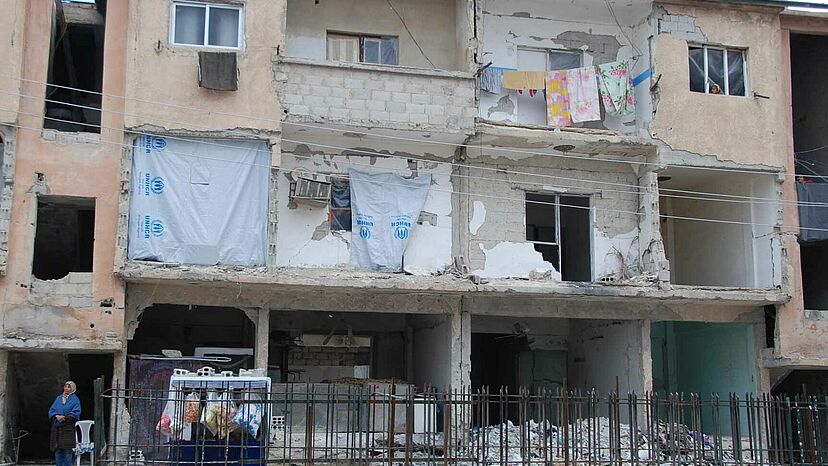 Ruinen als Unterschlupf In Städten kommen Flüchtlinge, Vertriebene und Rückkehrer nicht selten in halb zerstörten Häusern oder Bauruinen unter, wie hier in einem Vorort von Damaskus. Damit die Menschen sich vor Kälte und Wind zu schützen können, verteilte der UNHCR Baumaterial und Plastikplanen.
