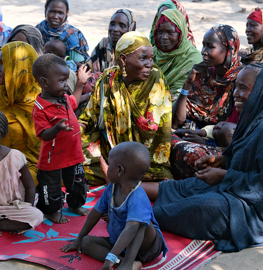 Familien sitzen auf Teppichen auf dem Boden