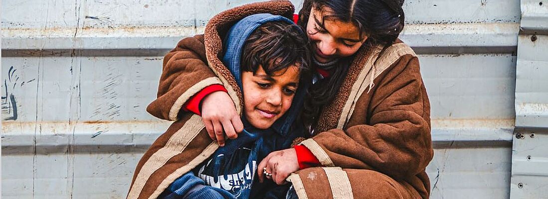 Al-Zaatari kuscheln sich die syrischen Geschwister Batul und Abdulaziz eng aneinander – gegen die Kälte, aber voller Hoffnung.