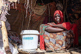 Flüchtlingsfrau mit UNHCR-Hilfsgütern