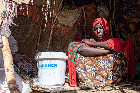 Flüchtlingsfrau mit UNHCR-Hilfsgütern