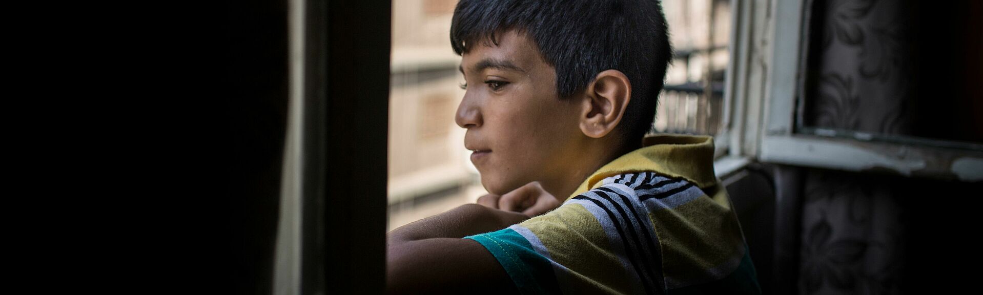 Junge schaut aus Fenster in Beirut