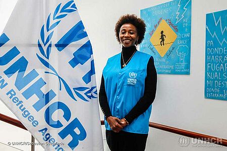 Juliette Murekeyisoni steht vor dem UNHCR-Logo