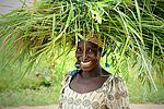 Afrikanerin mit Graspaket auf dem Kopf