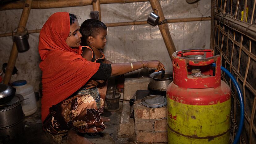 Kochen mit Gas
Rofiqua Begum und ihre Familie, die aus Myanmar geflohen sind, kochen mit Flüssiggas in Flaschen. Zuvor mussten sie Feuerholz sammeln, was die Umwelt schädigte und zu Spannungen mit der Gastgemeinde führte. Sie sagt, dass das Gas den Rauch in ihrer Unterkunft reduziert und die Gesundheit ihrer vier Kinder verbessert hat.