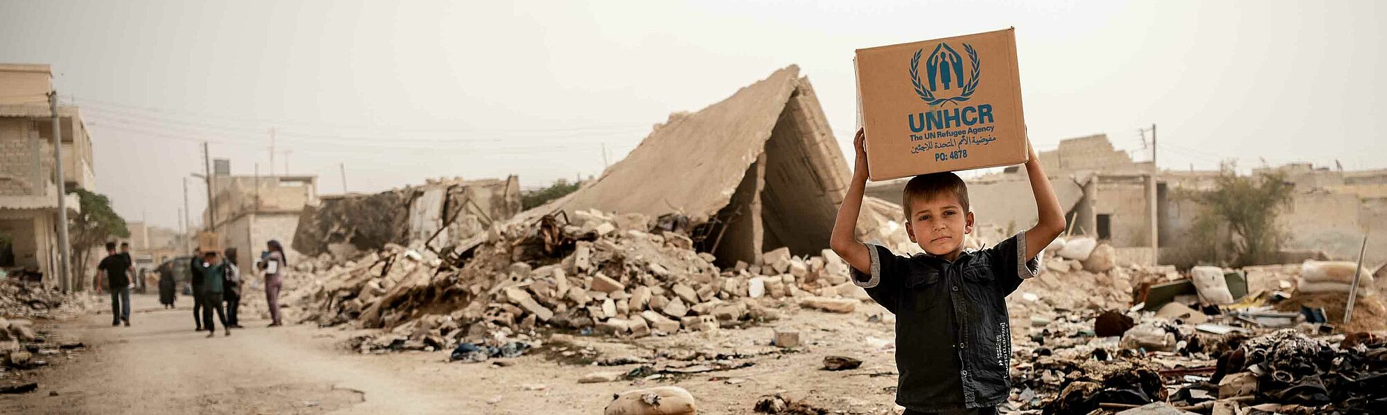 Junge mit UNHCR Nothilfe Paket in Syrien