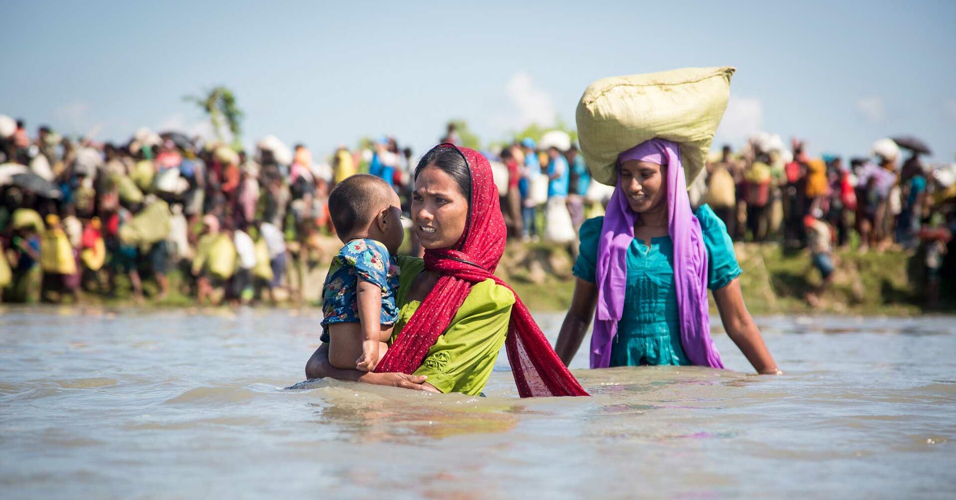 Rohingya Fraune in Fluss mit Kind auf dem Arm, Hindergrund Gruppe RF2131184_1920x1080.jpg