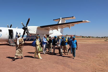 Gruppe von Menschen vor einem Flugzeug
