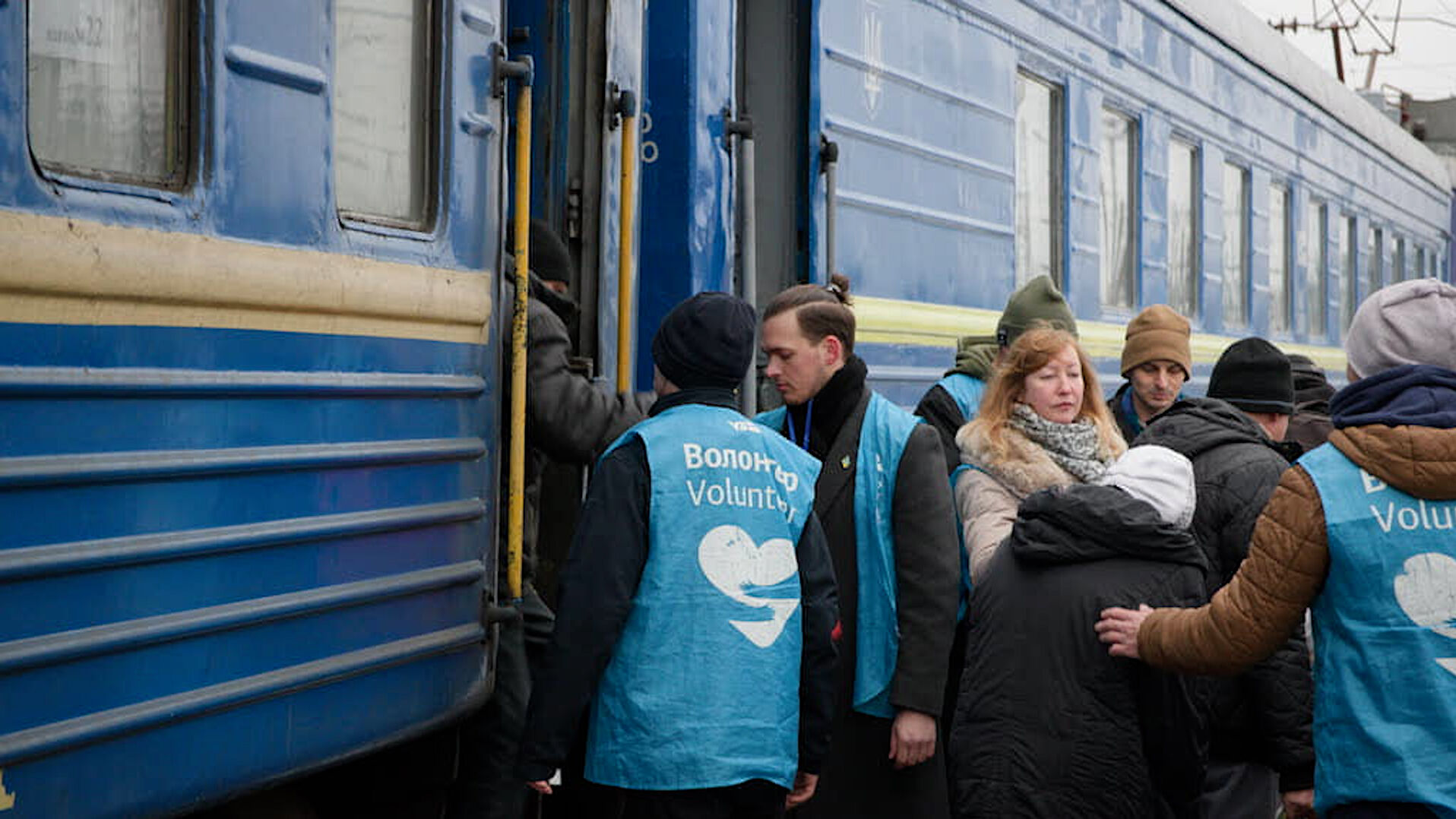 Freiwillige Helfer nehmen Flüchtlinge am Zug in Empfang