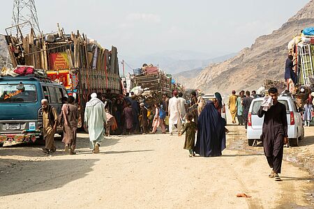 Straßenszene am Grenzübergang in Afghanistan mit Menschen und LKW