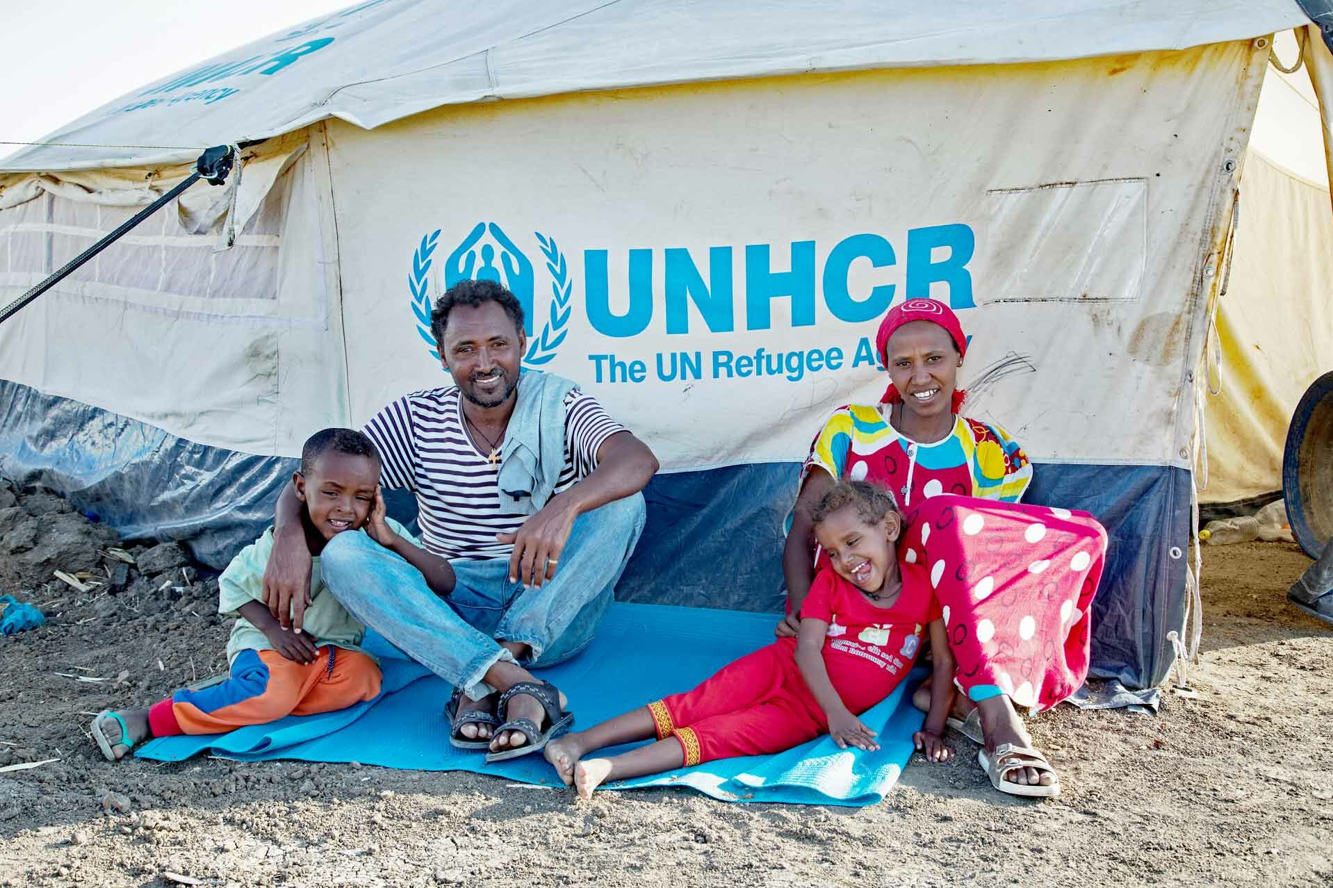 Flüchtlingsfamilie sitzt vor Zelt
