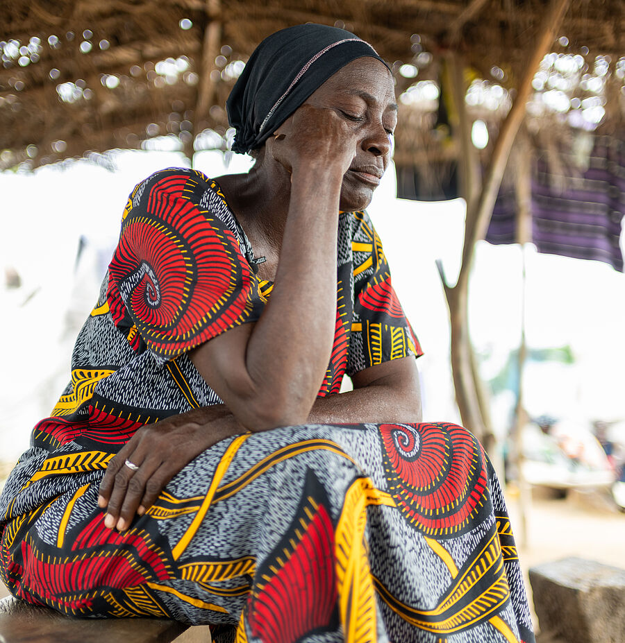 Nigerianische Frai sitzt mit dem Kopf auf den Händen abgestützt