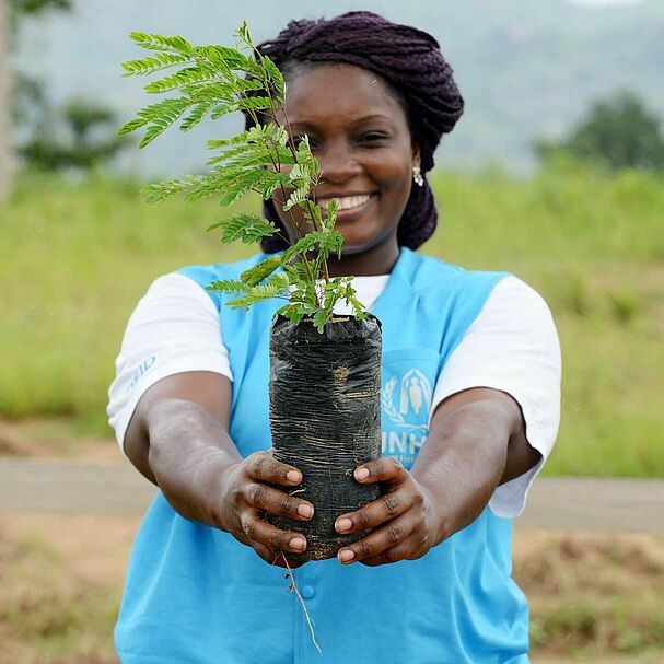 UNHCR-Helferin mit Pflanze
