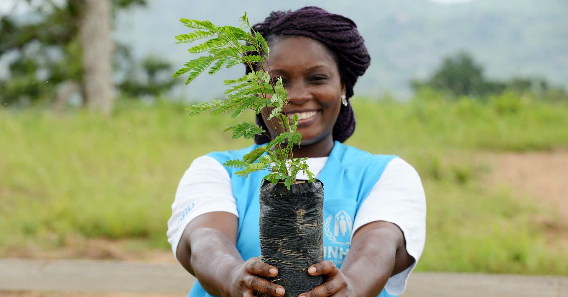 UNHCR-Mitarbeiterin mit Pflanze RF2129461_Unternehmenskooperationen.jpg
