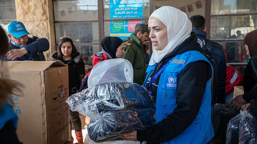 UNHCR-Helferin mit Hilfsgütern