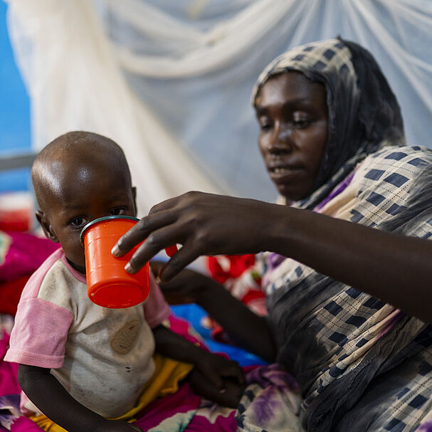 Eine Mutter füttert ihr mangelernährtes Kind