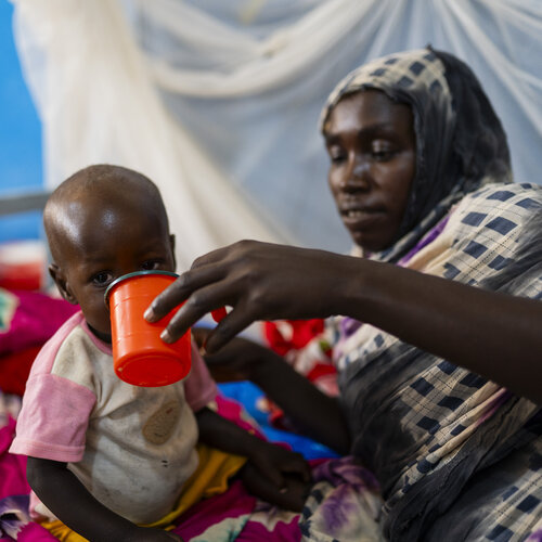Eine Mutter füttert ihr mangelernährtes Kind