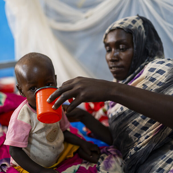 Eine Mutter füttert ihr mangelernährtes Kind