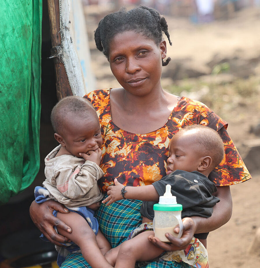 Afrikanische Mutter mit Kind auf dem Arm