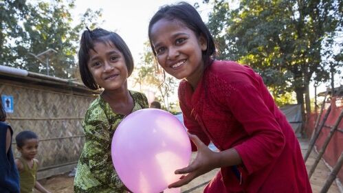 Zwei Rohingya-Mädchen freuen sich über einen Luftballon. Foto: UNHCR/R.Arnold