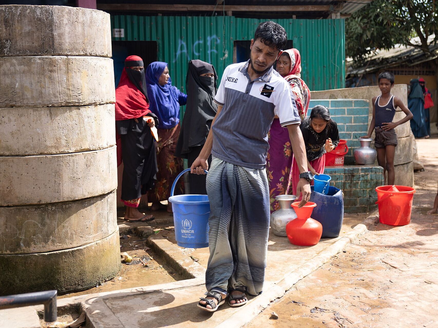 Ein Mann trägt einen Wassereimer