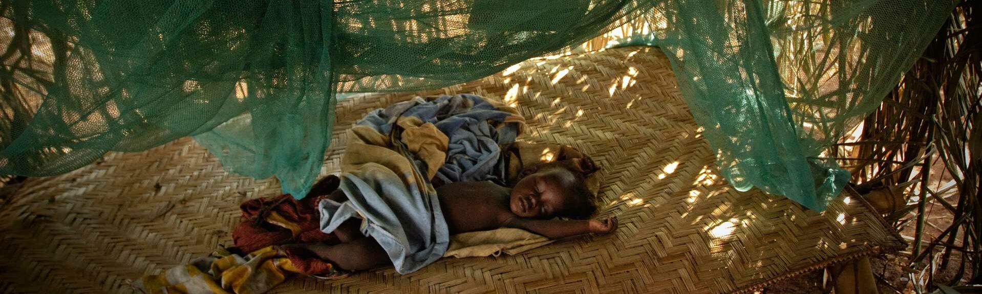 Malaria, Kind schläft unter Vorhängen