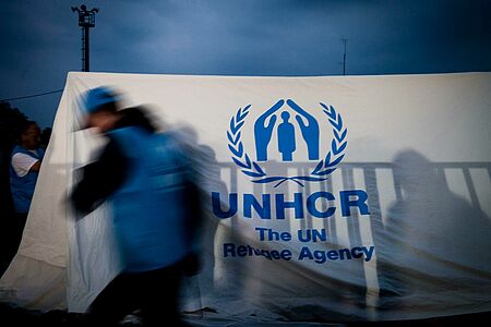 UNHCR-Helfer vor Flüchtlingszelt