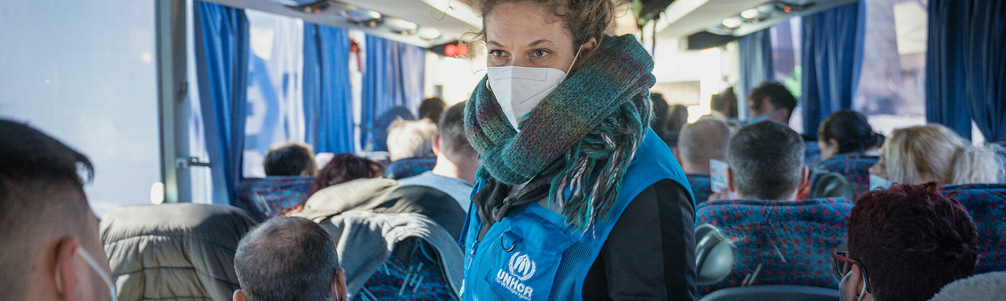 UNHCR-Helferin im Bus mit Flüchtlingen