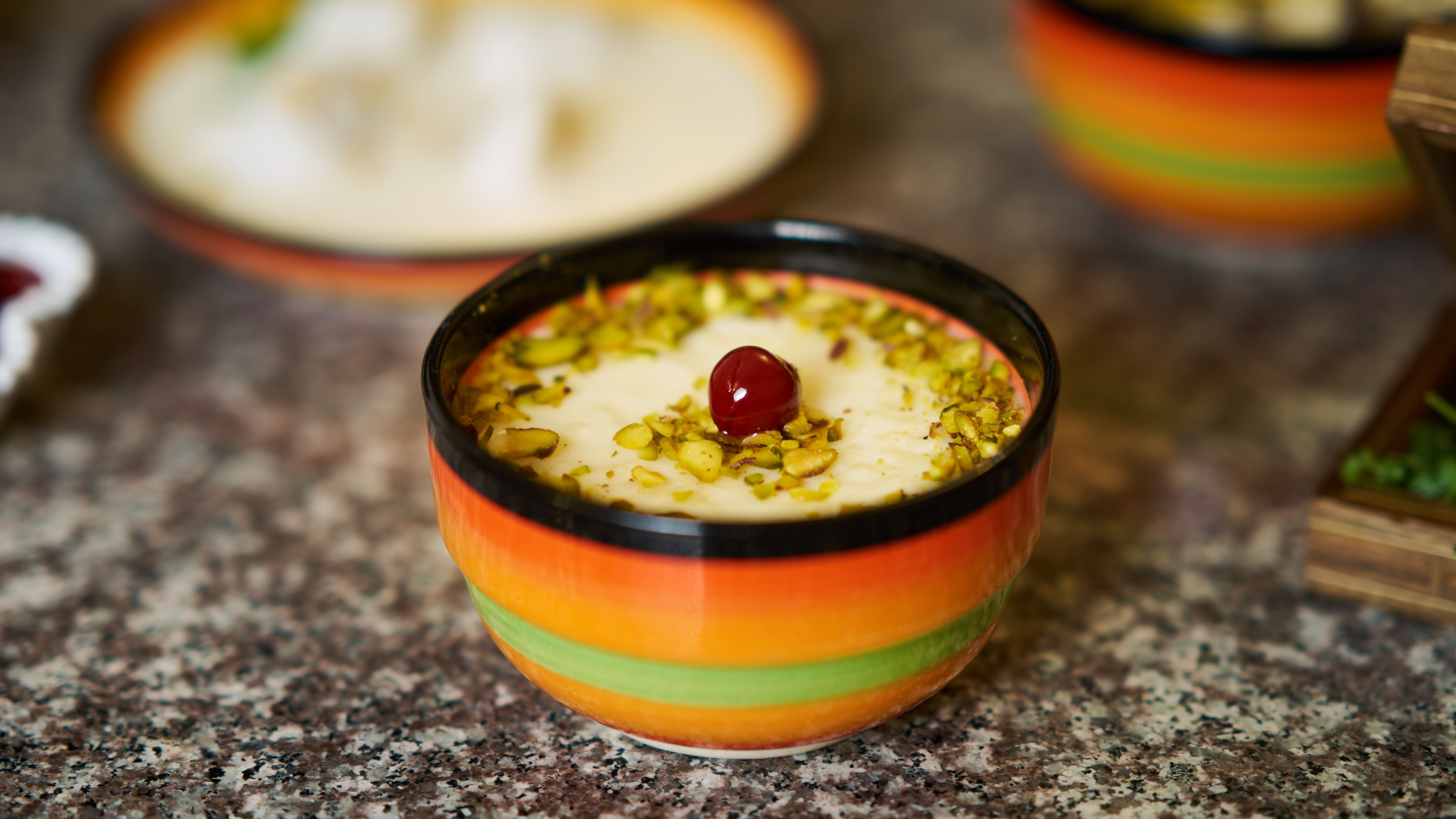 Eine kleine schale mit Nüssen und einer Kirsche garniertem Reispudding