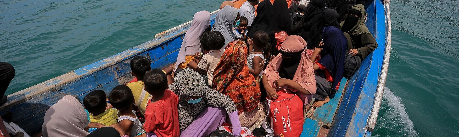 Großes überfülltes Schiff mit Land in Sicht