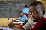 Kind mit Stift in Klassenraum 