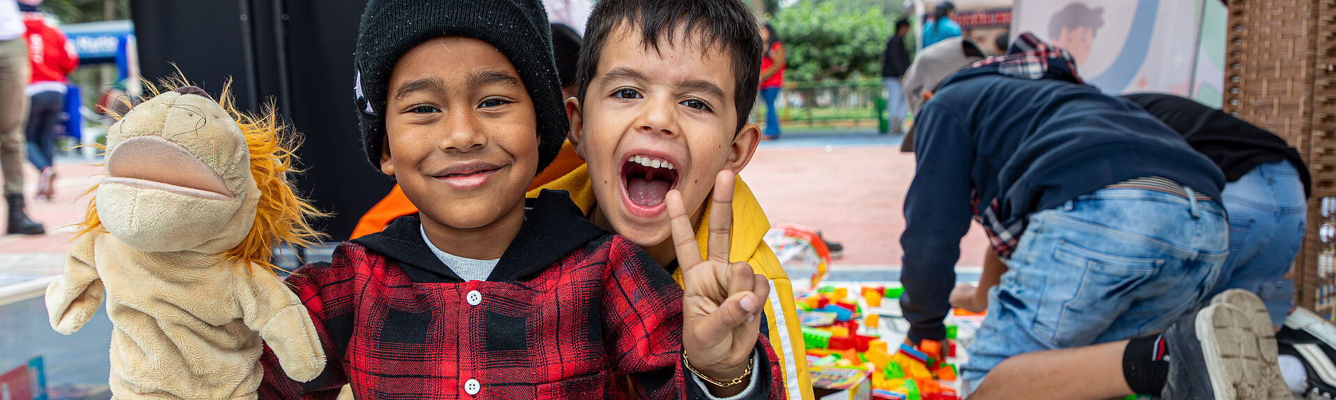 zwei Jungs  aus Venezuela, einer zeigt mit der Hand das Peace Zeichen und sie grinsen in die Kamera