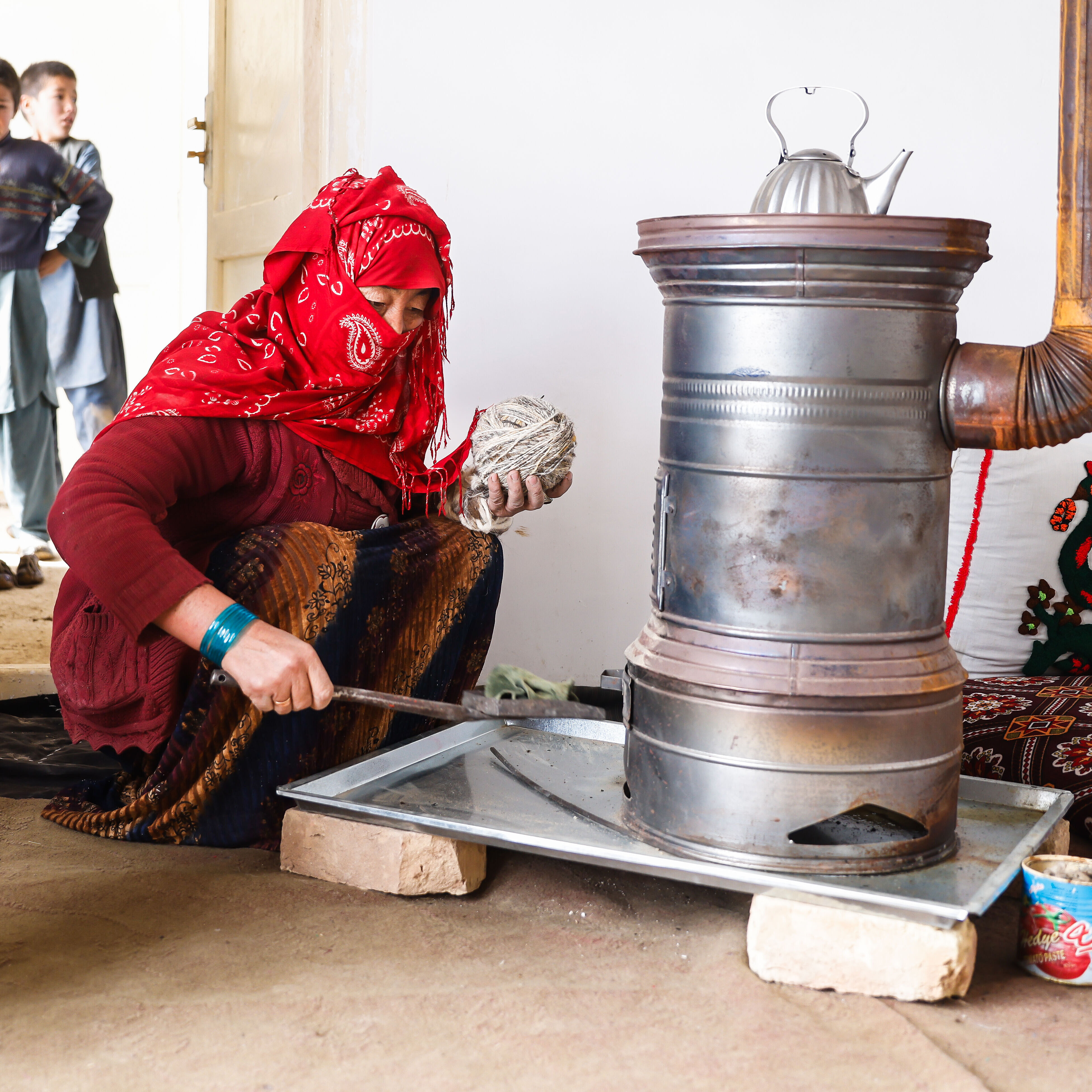 Eine Frau bedient einen altertümlichen Kamin