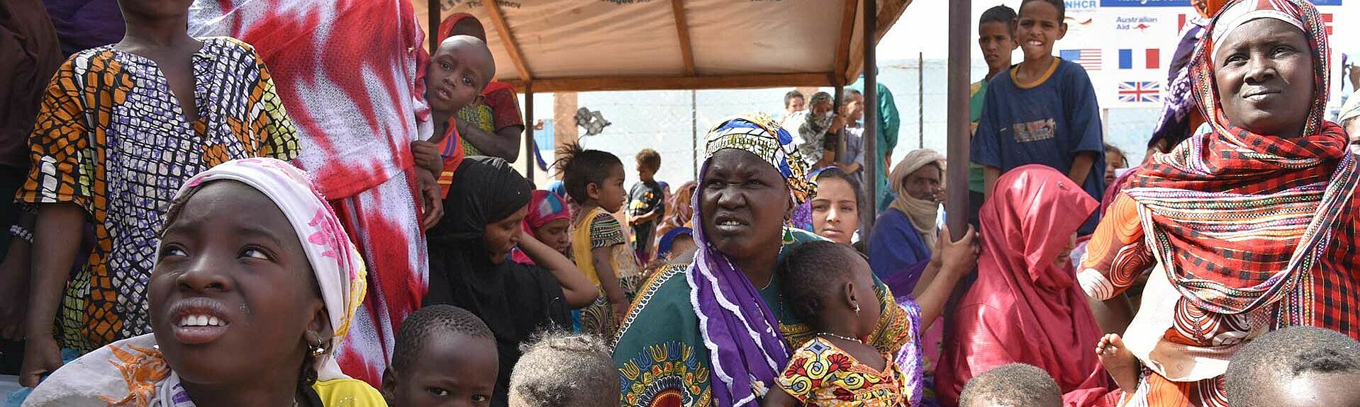 Atana (mit lilaem Kopftuch), eine malische Flüchtling aus dem Stamm der Fula, floh vor einigen Wochen mit ihrer Cousine und ihren Kindern aus Mopti und wartet auf die Registrierung im Lager Mbera in Mauretanien.