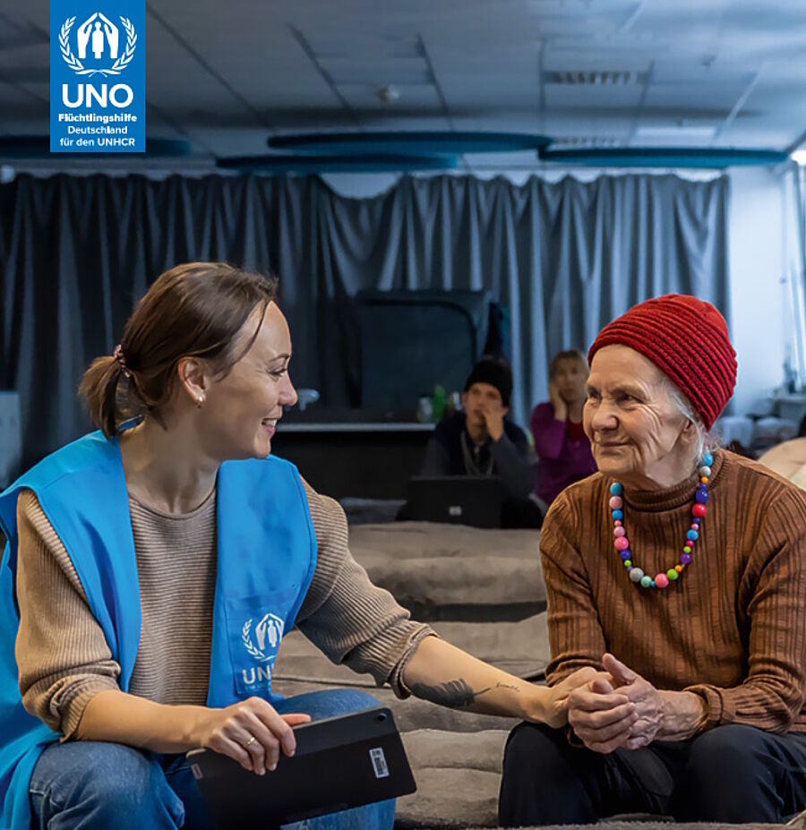 UNHCR-Mitarbeiterin und eine ältere Dame