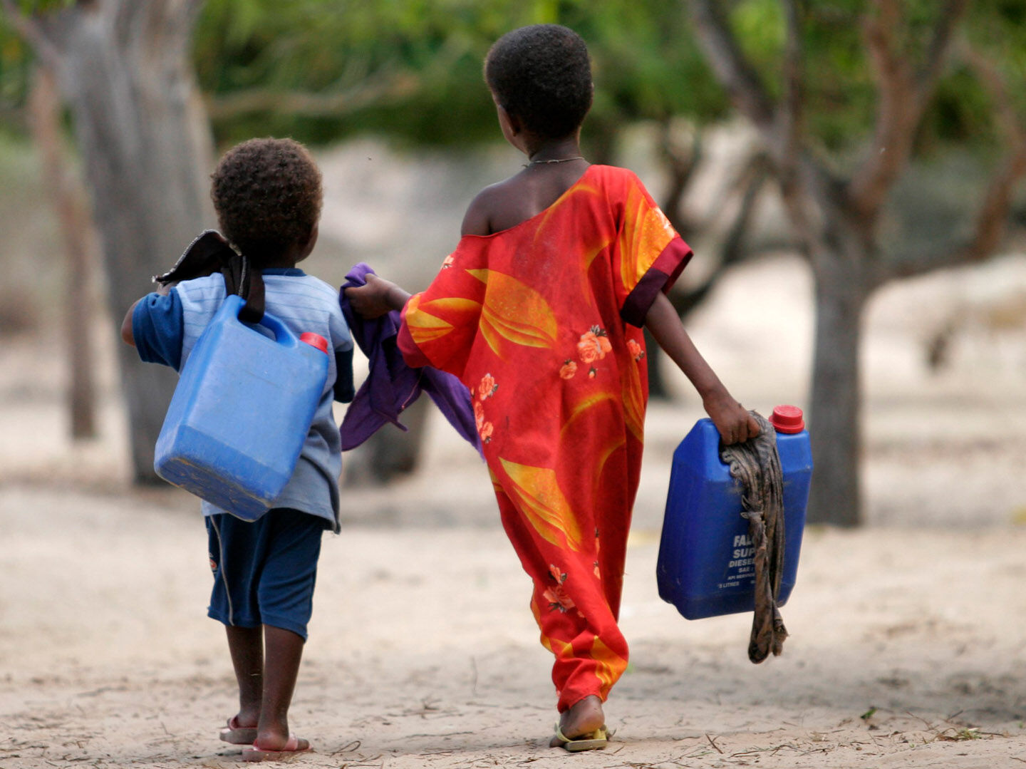 Zwei Kinder mit Kanister auf dem Weg um Wasser zu holen