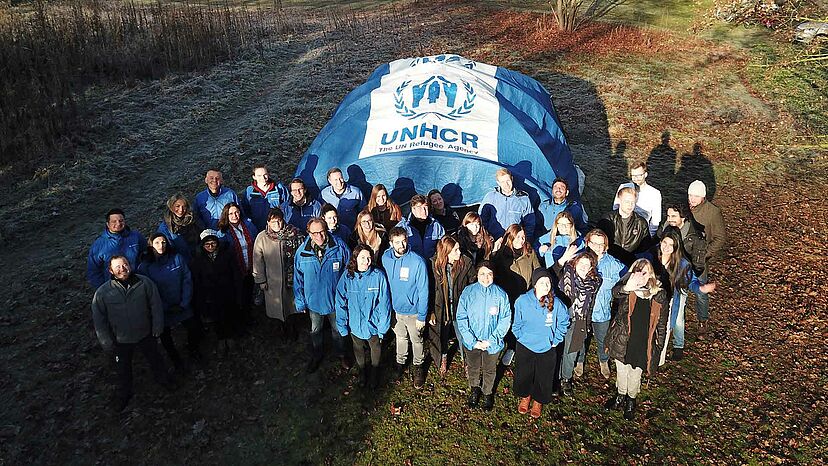 Das Team der UNO-Flüchtlingshilfe baut ein Familienzelt des UNHCR auf.