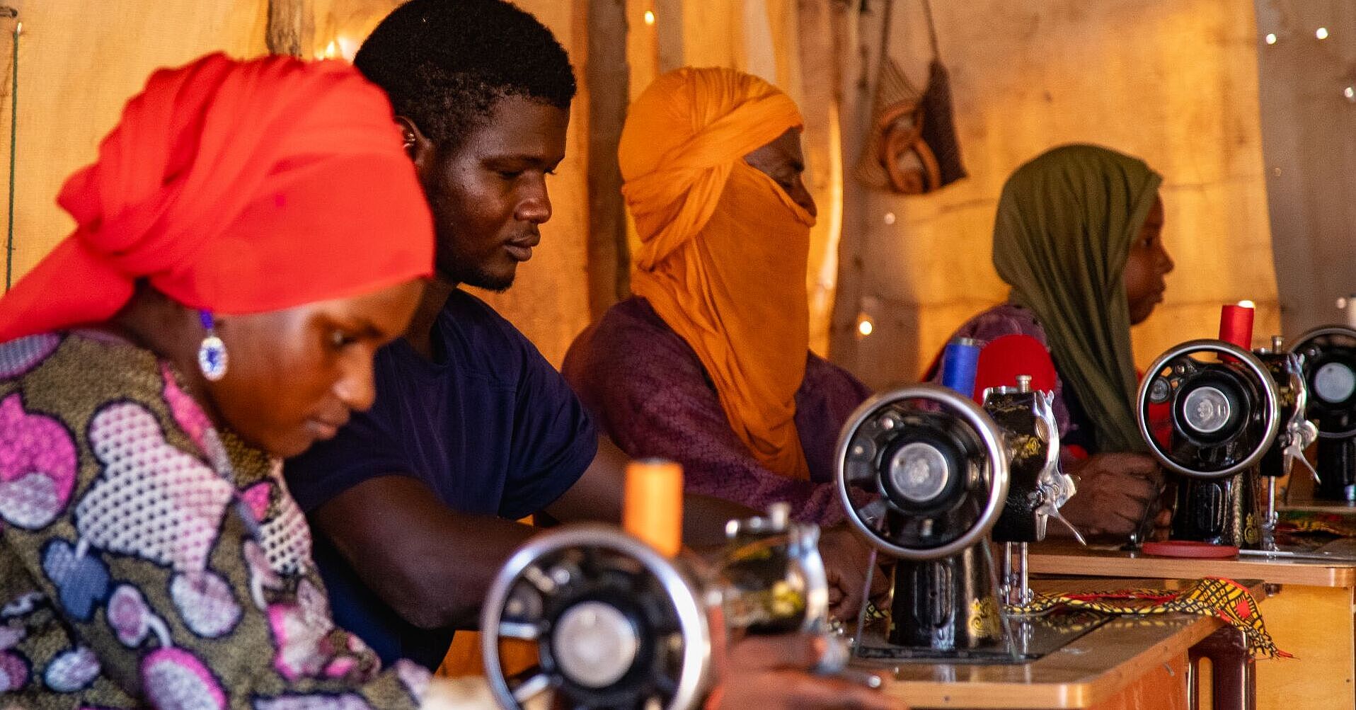 Einige Menschen nähen an Nähmaschinen Schneiderausbildung.jpg