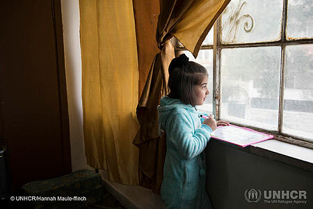 Syrisches Flüchtlingsmädchen blickt aus dem Fenster