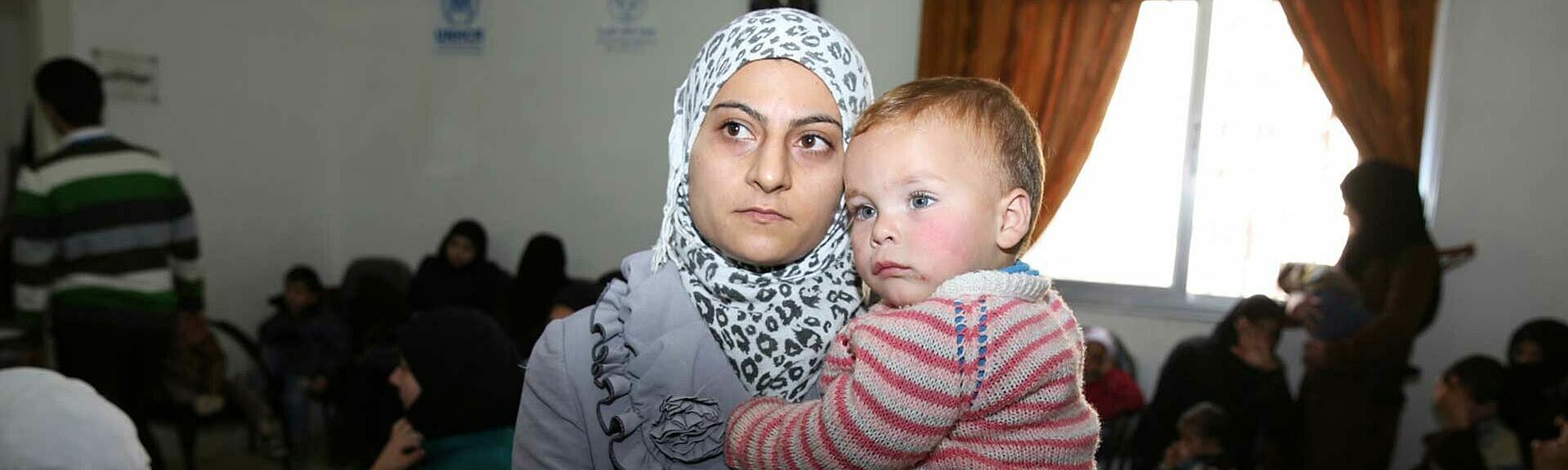Diese Frau wartet mit ihrem Neffen auf eine Behandlung in der UNHCR-Klinik Akramia in Aleppo. Foto: UNHCR