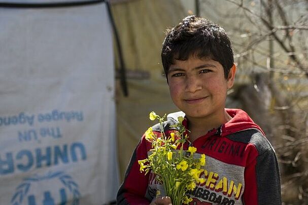Junge mit Blumen in der Hand