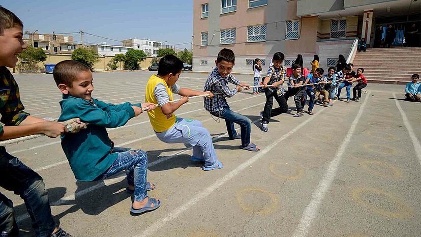 Afghanische Kinder in der iranischen Stadt Varamin spielen ein lebhaftes Spiel des Tauzeihen in ihrer Schule. Die meisten dieser Kinder sind im Iran geboren und haben Afghanistan noch nie besucht. Mehr als 500.000 Kinder sollen im Jahr 2021 in Grundschule und Weiterführendeschule eingeschult werden.