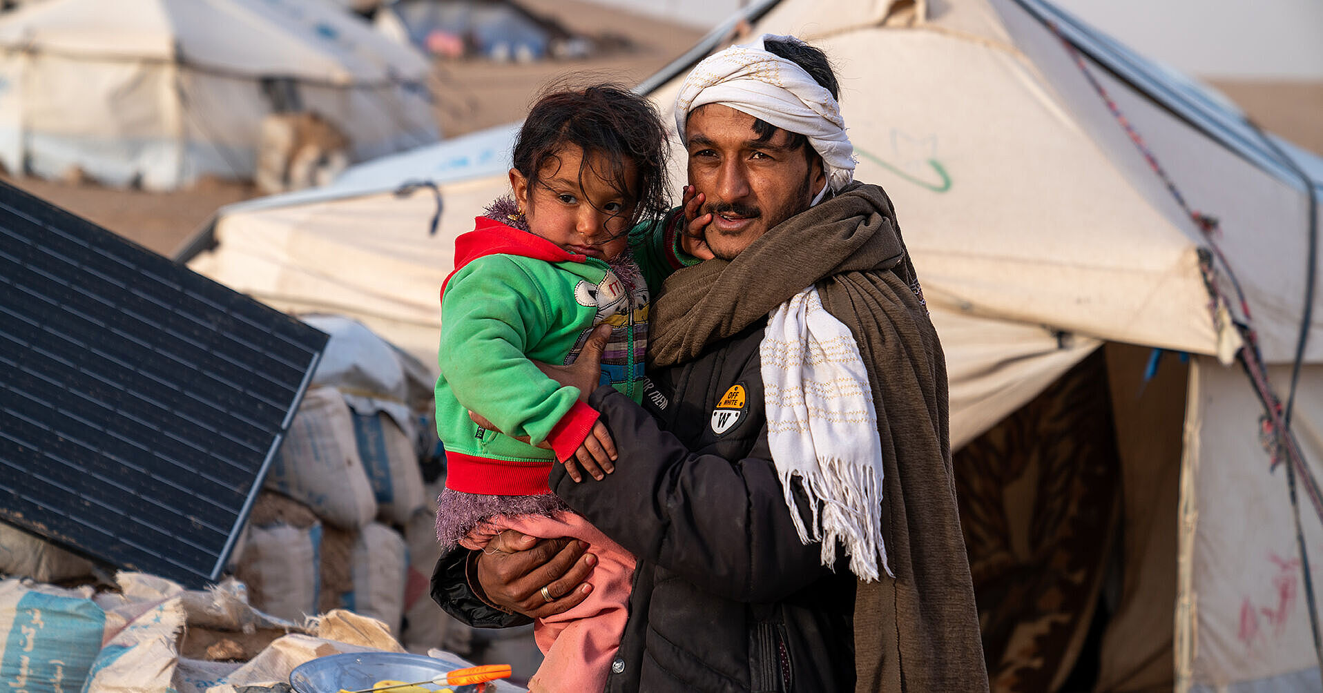 Afghanischer Vater mit Kind auf dem Arm vor Zelten Afghanistan_RF1340091_web.jpg