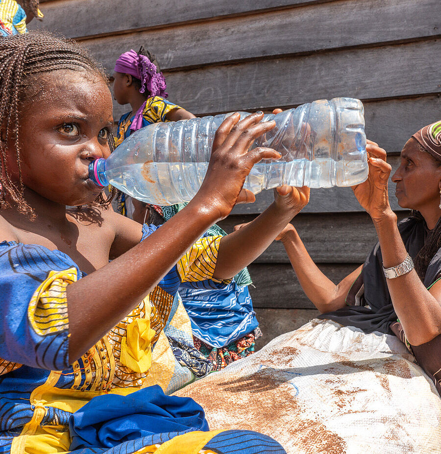 Kleines Mädchen trinkt Wasser aus einer Plastikflasche