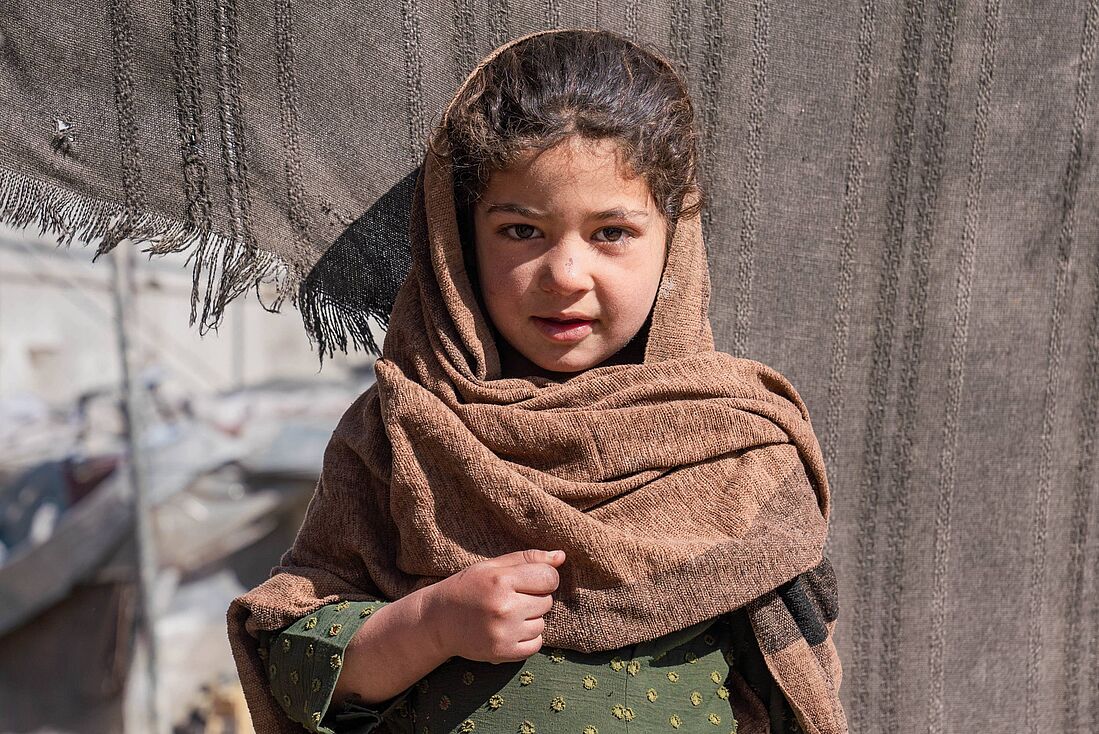 Die 6-jährige Nilofar lebt mit ihrer Familie in einem Zelt in einer informellen Siedlung, wo sie mit den Herausforderungen der Vertreibung und den harten Lebensbedingungen konfrontiert ist. 