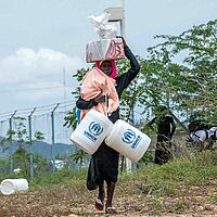 Flüchtlinge mit Wasserkanistern